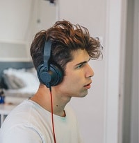 young boy using wired headphones