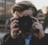 person holding a canon camera.