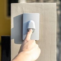 Man's hand pressing a doorbell button