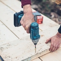Woman using impact driver outdoors