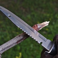 Using a survival knife to make an arrow