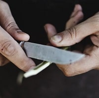 man sharpening small knife